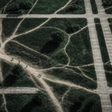 Aerial view of worn footpaths cutting across a formal paved grid, showing the informal routes people actually use