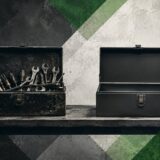 Two toolboxes on a workbench, the left one worn and full of well-used tools, the right one new and empty